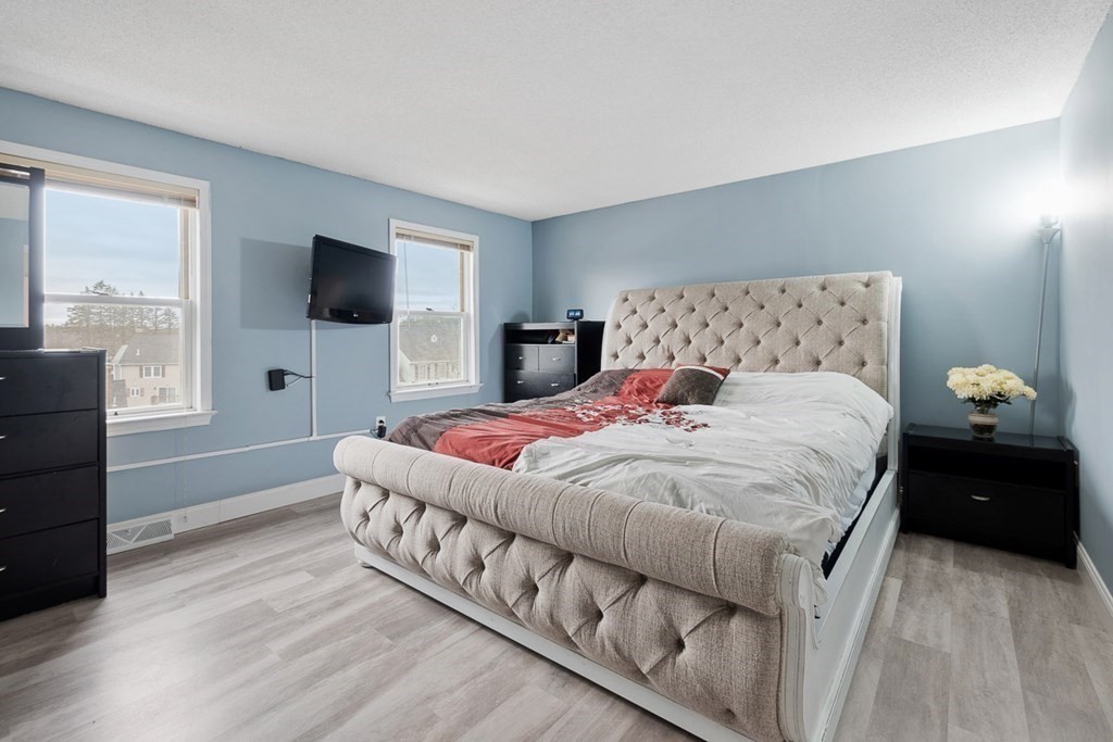 25 Century Way, Unit 25 Gardner, MA 01440 - Photo 22 of 34 a bedroom with a large bed and a flat tv screen on a dresser