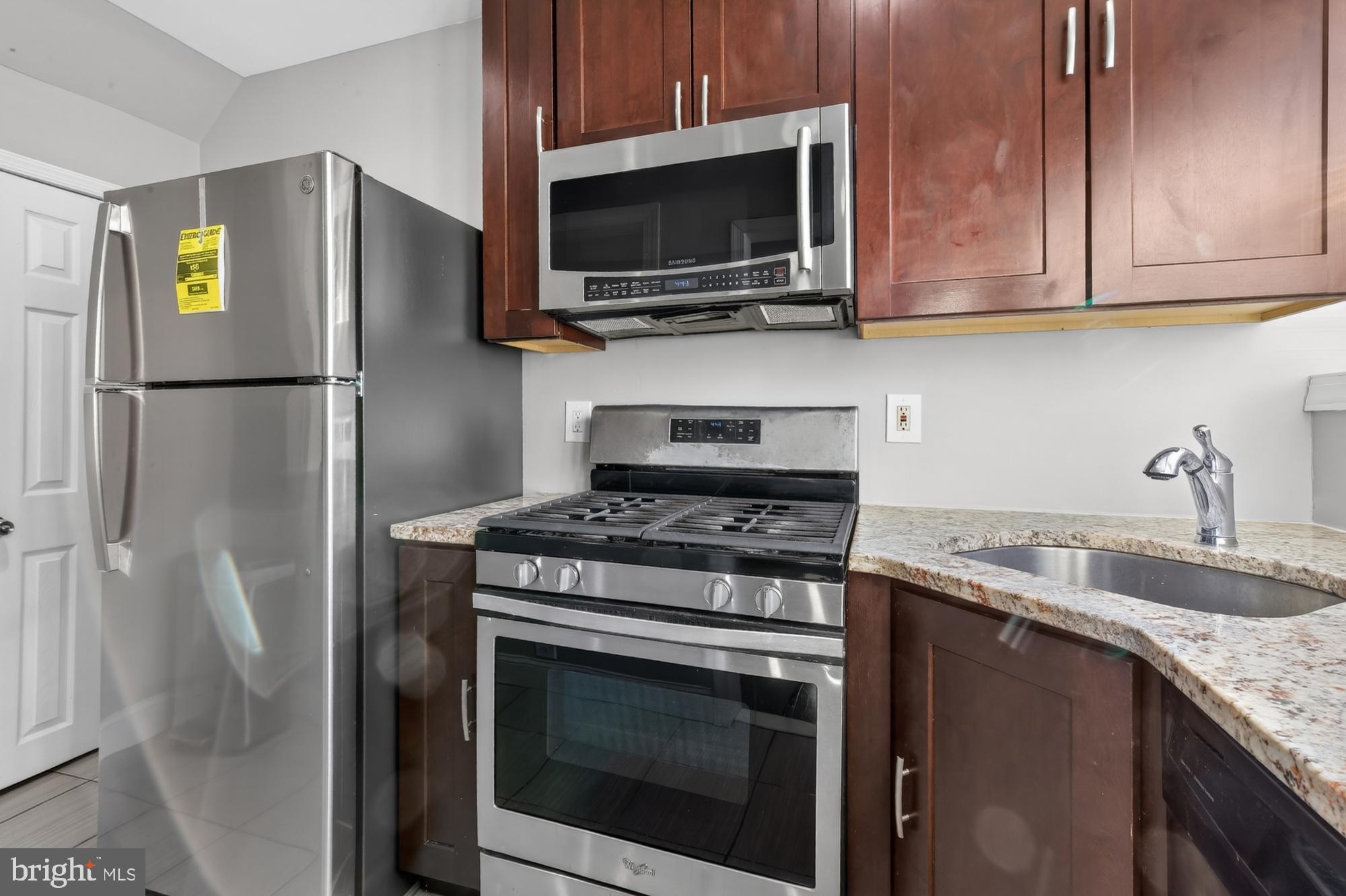 1640 South 28th Street Philadelphia, PA 19145 - Photo 7 of 27 a kitchen with stainless steel appliances granite countertop a refrigerator stove and microwave
