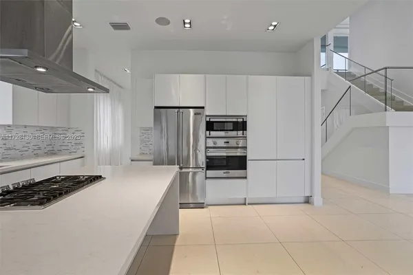 a kitchen with stainless steel appliances a refrigerator and a stove top oven