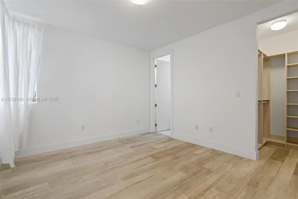an empty room with wooden floor and a window