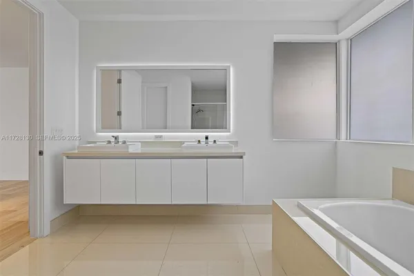 a bathroom with a bathtub sink and mirror