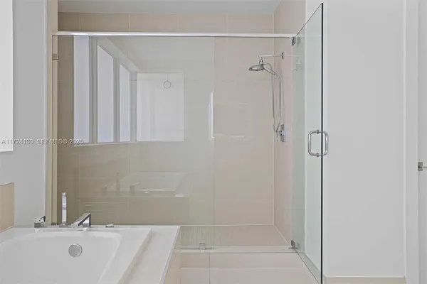 a bathroom with a tub shower and a sink