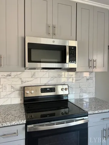 a kitchen with granite countertop white cabinets and stainless steel appliances