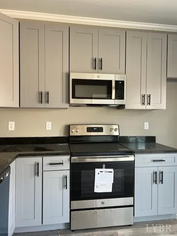 a kitchen with granite countertop white cabinets and stainless steel appliances