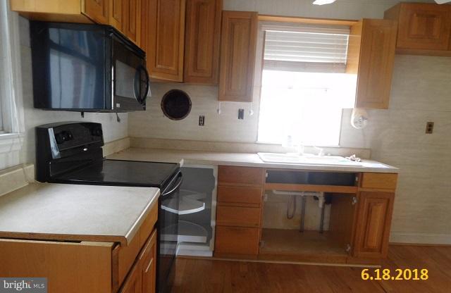 1234 Hillside Road Pasadena, MD 21122 - Photo 2 of 12 a kitchen with a sink a microwave and cabinets