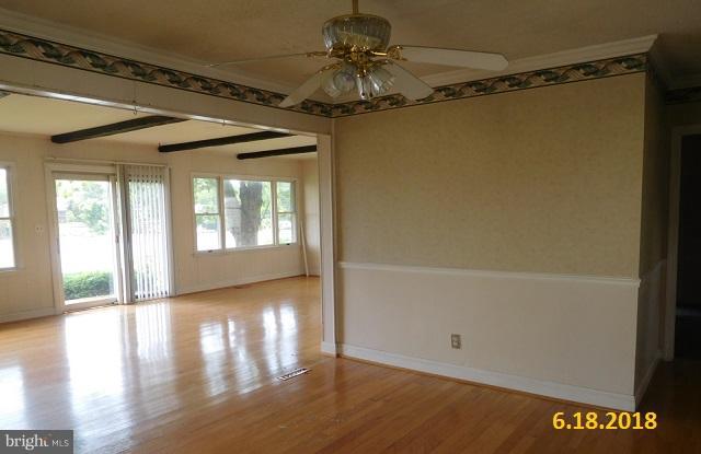 1234 Hillside Road Pasadena, MD 21122 - Photo 4 of 12 a view of a room with wooden floor a ceiling fan and a window
