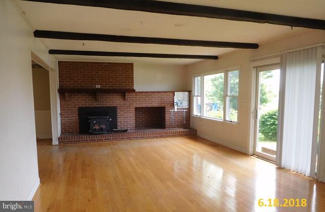 1234 Hillside Road Pasadena, MD 21122 - Photo 8 of 12 a view of an empty room with a fireplace and a window