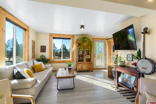 a living room with furniture a flat screen tv and a large window