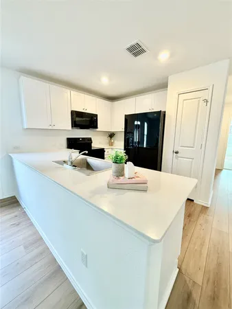 a kitchen with stainless steel appliances a refrigerator sink stove and microwave