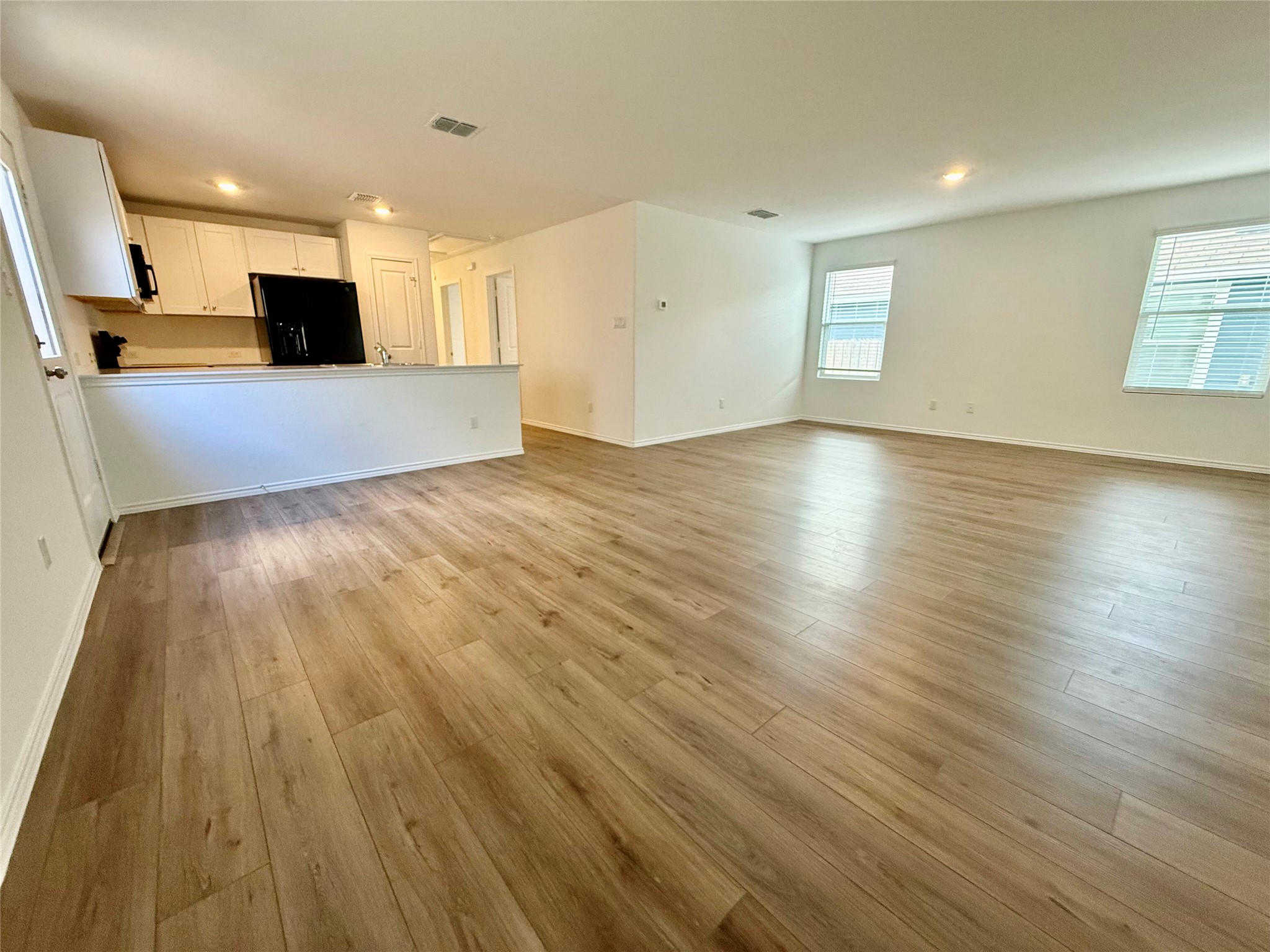 716 Commander Abbott Drive Jarrell, TX 76537 - Photo 5 of 17 an empty room with wooden floor and windows