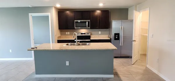 a kitchen with stainless steel appliances a sink stove and refrigerator