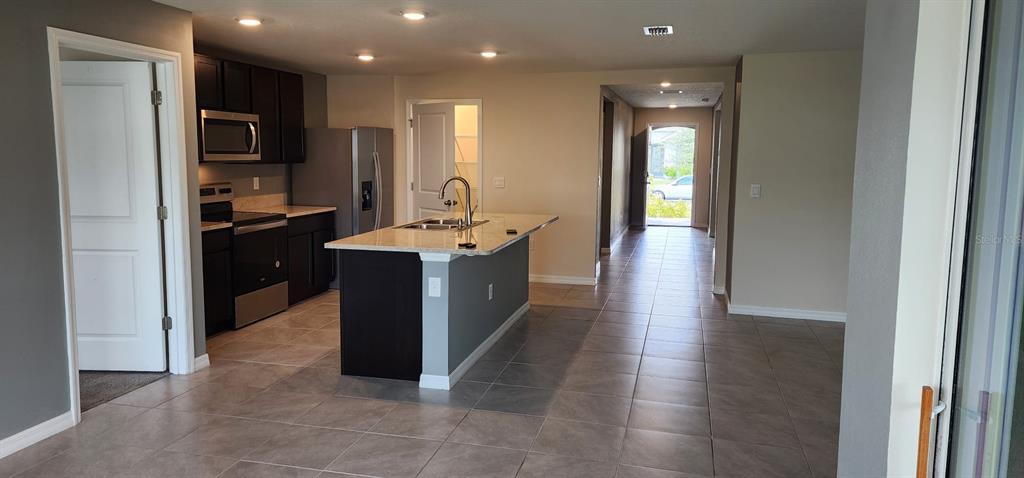 16778 Carlton Pond Street Wimauma, FL 33598 - Photo 13 of 27 a kitchen with stainless steel appliances granite countertop a refrigerator a sink and a stove