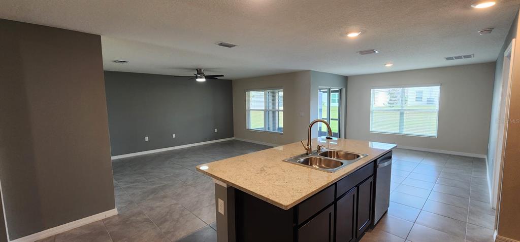 16778 Carlton Pond Street Wimauma, FL 33598 - Photo 15 of 27 a living room with kitchen island furniture and a window