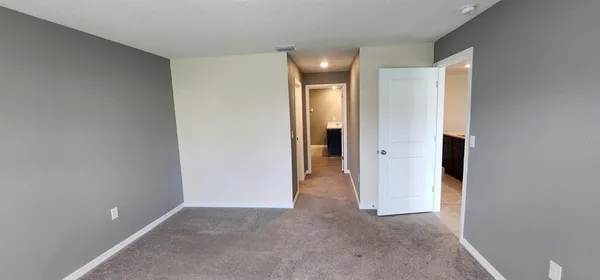 an empty room with closet and a bathroom