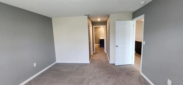 an empty room with closet and a bathroom