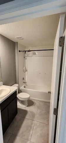 a bathroom with a granite countertop shower toilet and sink