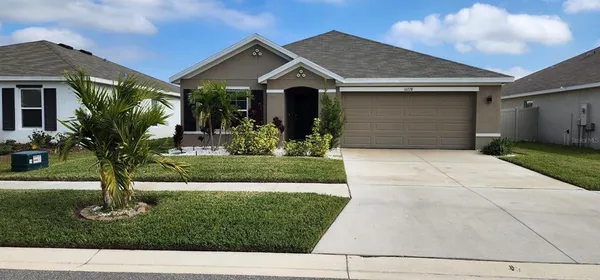 a front view of a house with a yard and potted plants