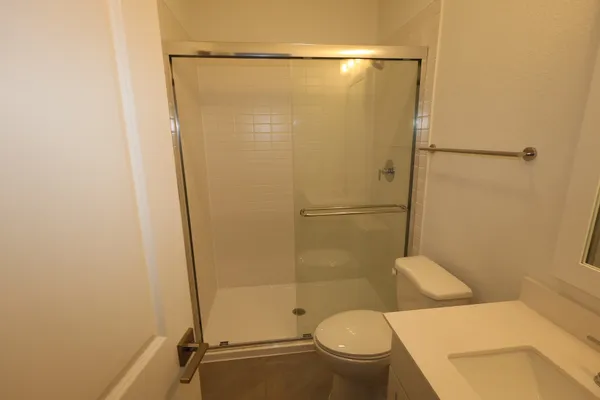 a large kitchen with a large counter top a refrigerator and a sink