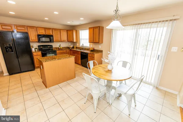 a kitchen with stainless steel appliances granite countertop a stove top oven a sink and a refrigerator