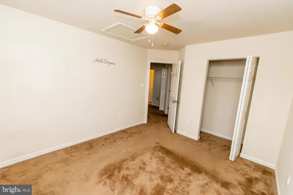 an empty room with a ceiling fan and window