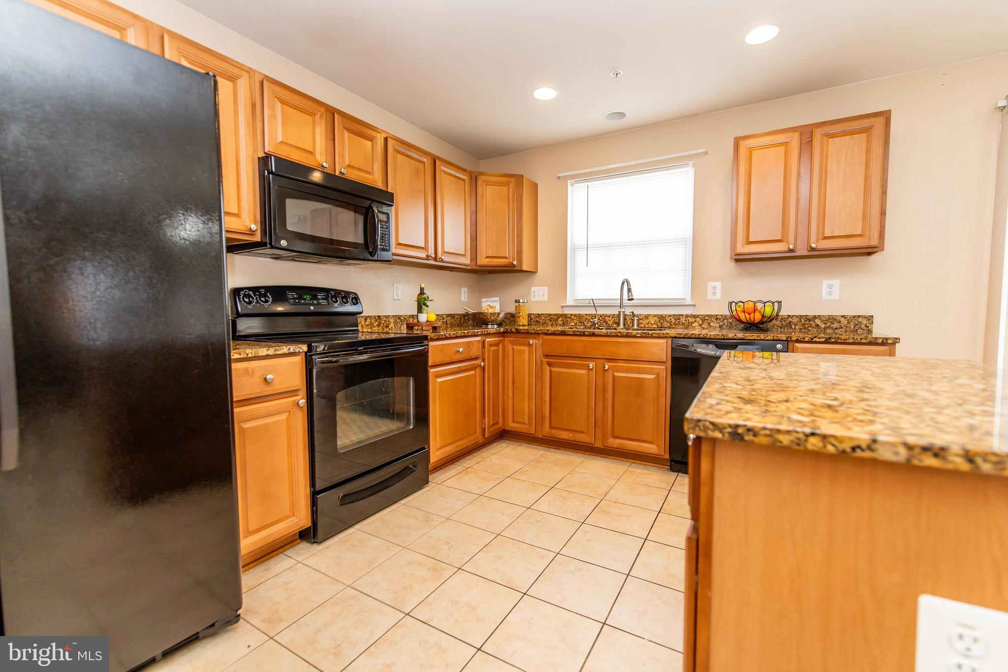 13400 Oaklands Manor Drive Laurel, MD 20708 - Photo 4 of 44 a kitchen with stainless steel appliances granite countertop a stove a sink dishwasher and a microwave oven with white cabinets