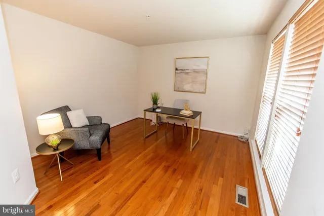a bedroom with a bed table chair and a window