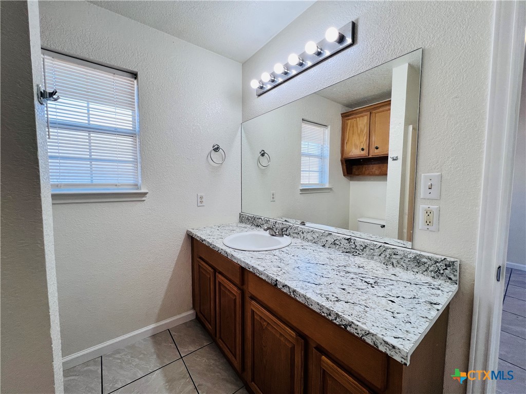 1704 Boydstun Loop Killeen, TX 76542 - Photo 7 of 11 a bathroom with a granite countertop sink and a mirror