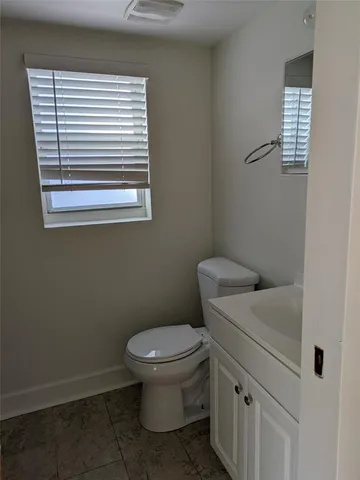 a bathroom with a toilet sink and window