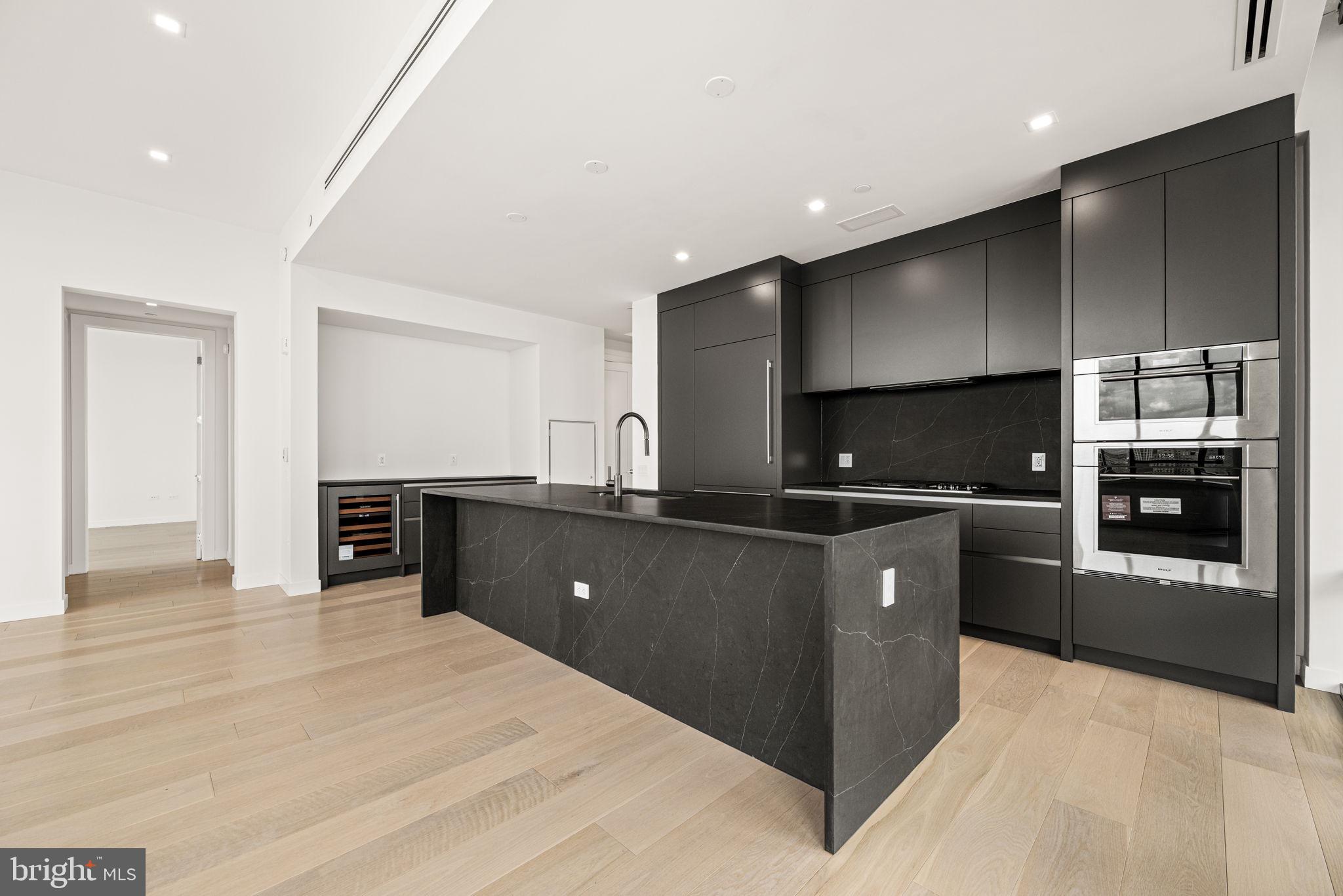 1911 Walnut Street, Unit 3404 Philadelphia, PA 19103 - Photo 4 of 37 a kitchen with stainless steel appliances kitchen island granite countertop a refrigerator and a stove top oven