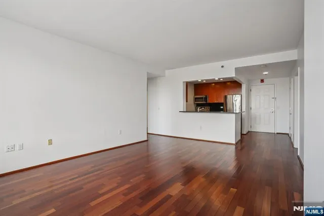 a view of a room with wooden floor and a flat screen tv