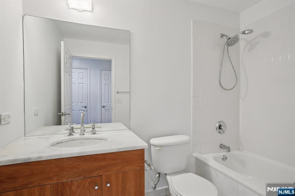 3110 City Place Edgewater, NJ 07020 - Photo 21 of 36 a bathroom with a granite countertop sink toilet and shower