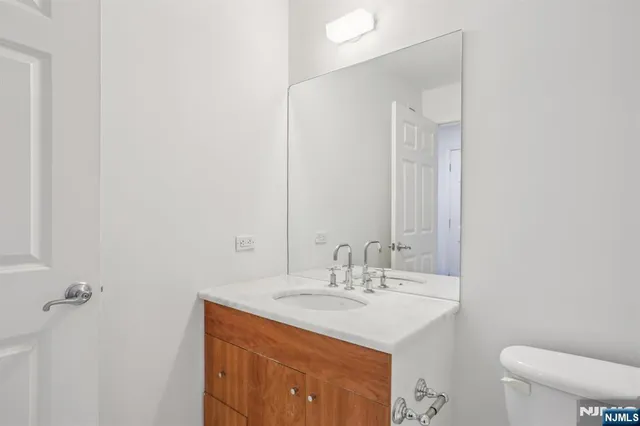 a bathroom with a sink a toilet and mirror