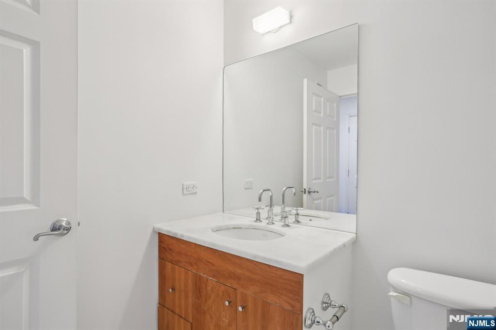 3110 City Place Edgewater, NJ 07020 - Photo 22 of 36 a bathroom with a sink a toilet and mirror