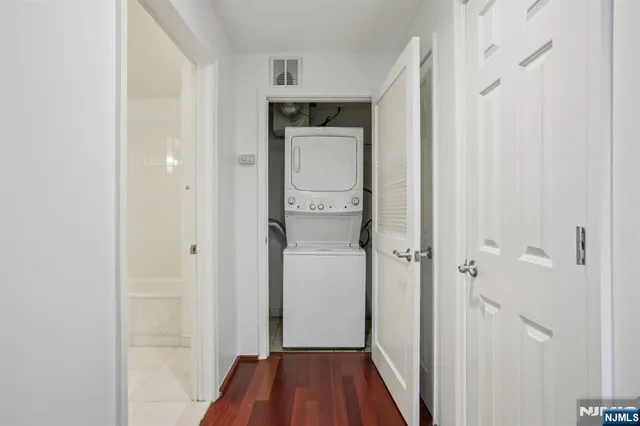 a walk in closet with wooden floor