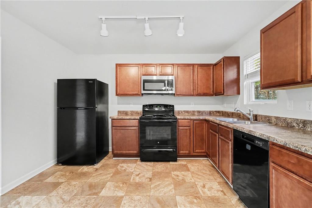 1235 To Lani Path Stone Mountain, GA 30083 - Photo 11 of 33 a kitchen with granite countertop a refrigerator and a stove