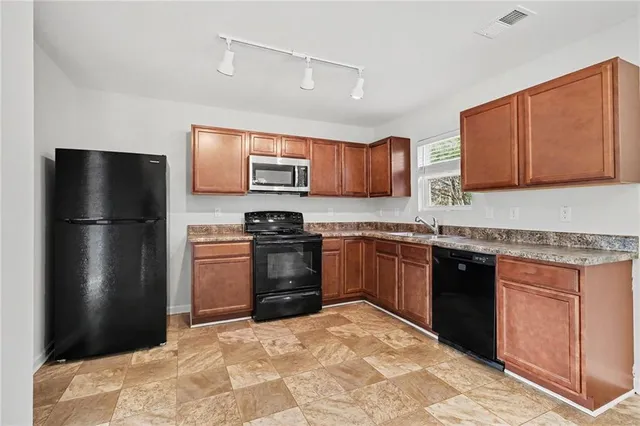 a kitchen with stainless steel appliances granite countertop a refrigerator stove and microwave