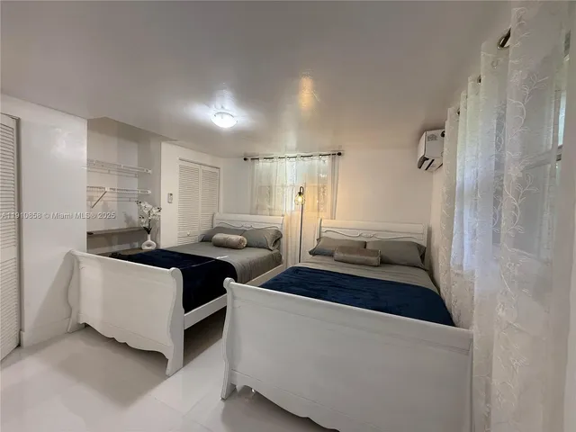 a spacious bedroom with a bed and a chandelier