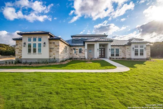 a view of a white house with a large pool and a yard