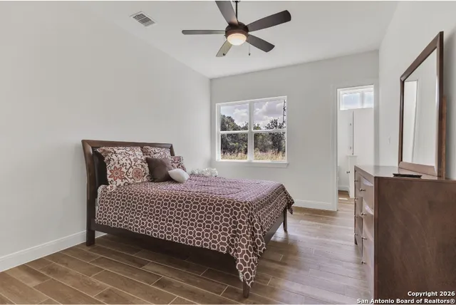 a bedroom with a bed and wooden floor