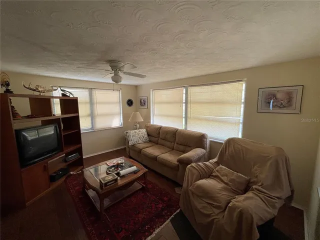 a living room with furniture a flat screen tv and a window