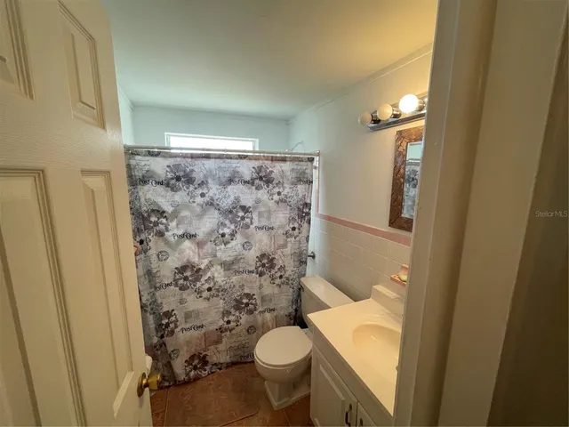 a bathroom with a granite countertop toilet and a shower
