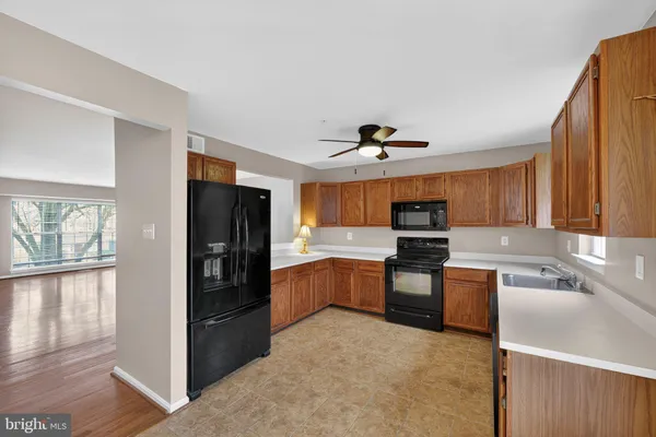a kitchen with granite countertop a refrigerator stove top oven and sink