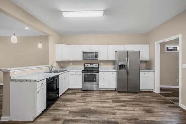 a kitchen with a refrigerator and a stove top oven