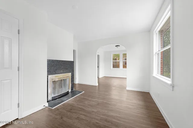 a view of an empty room with window and fire place