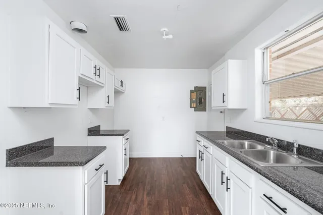 a kitchen with granite countertop a sink a stove and refrigerator