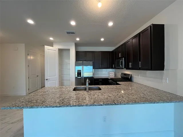 a large kitchen with a table and chairs
