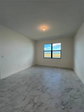 a bathroom with a granite countertop sink a large mirror and a wooden cabinets