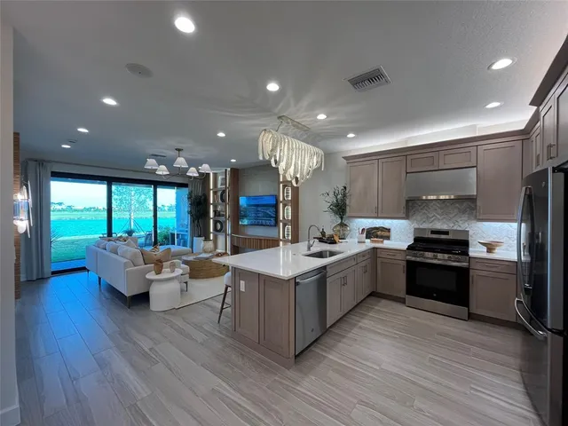 a large kitchen with kitchen island granite countertop a sink and a stove