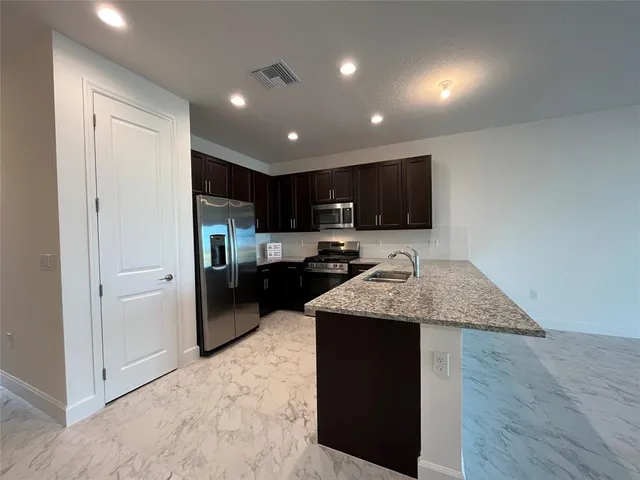 a living room with furniture kitchen and a wooden floor