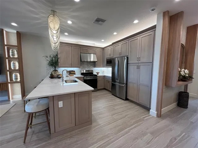 a living room with furniture kitchen and a chandelier